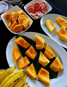 阿皮亚萨摩亚瓦伊酒店的桌上有三盘带橙子和水果的食物