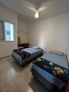 乌巴图巴Apê212 - 650m da Orla的一间卧室配有两张床和吊扇
