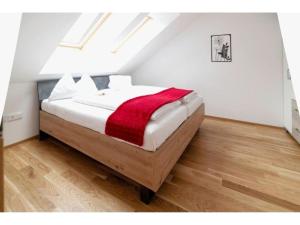 上陶恩Apartment in Hohentauern with sauna的一间卧室配有一张床铺,床上铺有红色毯子