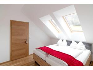 上陶恩Apartment in Hohentauern with sauna的一间卧室配有一张床铺,床上铺有红色毯子