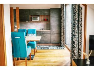上陶恩Apartment in Hohentauern with sauna的一间带桌子和蓝色椅子的用餐室