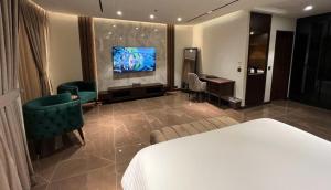 伊斯兰堡Jacaranda Heights的酒店客房配有一张床、一张书桌和一台电视。