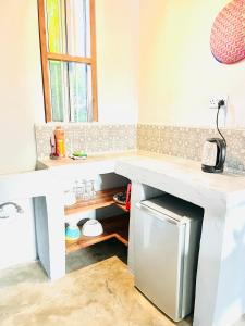 布韦朱Butterfly Apartment Zanzibar的厨房配有台面和冰箱