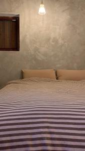 金湖镇而雨的一间卧室配有一张床,床上有条纹毯子