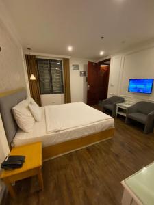 河内Khách Sạn A83Hotel的一间带大床的卧室和一间客厅