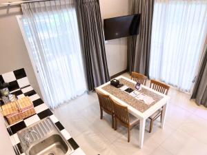 邦盛Bangsaen Heritage Hotel - SHA Plus Certified的一间带桌椅和窗户的用餐室