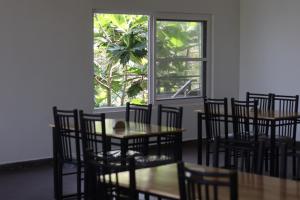 库斯哈尔纳加尔Mazra Retreat, Coorg Kushālnagar的一间带桌椅的用餐室和窗户。