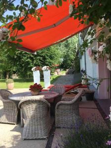 布兰肯贝赫Polderlicht的露台的红色遮阳伞下的桌椅