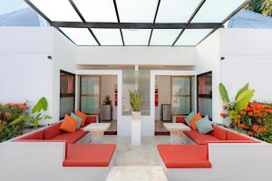 塞米亚克巴厘岛姜套房别墅的庭院配有红色家具和橙色枕头。