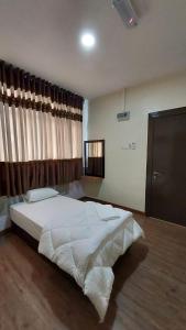 马六甲Hotel Bestari的卧室设有一张白色大床和一扇窗户。
