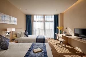 石家庄石家庄诺华廷酒店 Novlion hotel的酒店客房设有两张床和一台平面电视。