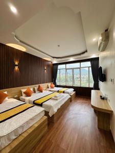 高平Minh Hoang Hotel & Homestay的一间卧室设有三张床和大窗户