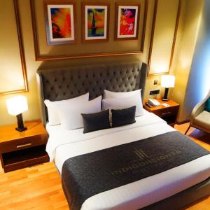 拉合尔Indigo Heights Hotel & Suites的酒店客房设有一张大床和两盏灯。