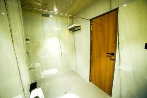 瓦拉纳西Hotel Surya, Kaiser Palace的带淋浴和卫生间的浴室以及木门。