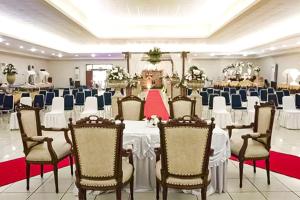 雅加达Hotel 678 Cawang powered by Cocotel的宴会厅,室内配有白色的桌椅