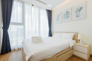 河内Royal Serviced apartment Vinhomes Metropolis的卧室配有一张大白色床和窗户