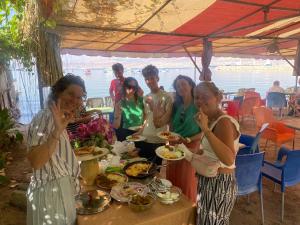 亚喀巴Al-Amer Hostel 2的一群人站在桌子旁吃着食物
