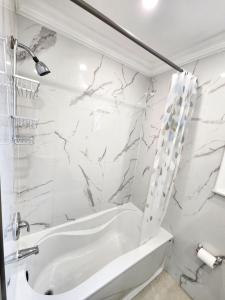 多伦多Toronto Uptown 3的白色的浴室设有浴缸和淋浴。