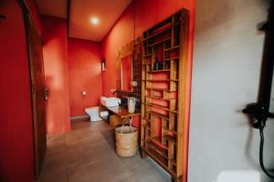 塞隆贝拉纳克Disini Lombok ECO Sky House, Selong Belanak的一间带红色墙壁和木制书架的浴室