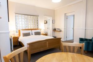 普里茅斯普利茅斯格罗夫纳酒店的卧室配有1张床、1张桌子和1把椅子