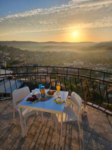 大特尔诺沃TOP SKY VIEW - Studio Panorama的阳台上的一张桌子,上面摆放着食物和饮料,还可欣赏到日落美景