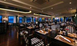 下龙湾Genesis Luxury Regal Cruises的餐厅内带桌椅的用餐室