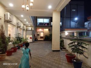 AmbikāpurGRS, Hotel The Grand Radhe Shyam, Ambikapur的穿着绿色衣服的女人在建筑物里走