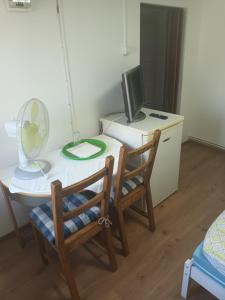 普洛耶什蒂Camera con bagno的客房设有一张桌子、一台电脑和两把椅子