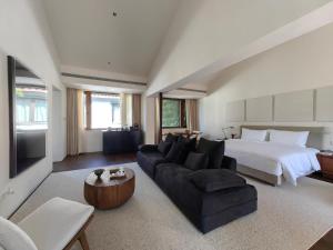 苏州苏州畅园有熊酒店的客厅配有床、沙发和床。