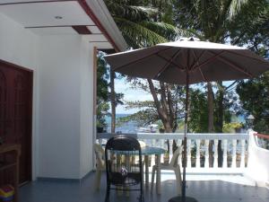 邦劳前海度假民宿的阳台配有桌椅和遮阳伞