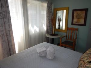 比勒陀利亚Solitaire Guest Apartments的一间卧室配有带毛巾的床