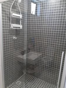 温特和克City View Unit 130 at 77 on Independence的浴室设有黑色瓷砖和淋浴。
