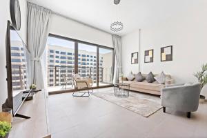 迪拜StoneTree - Spacious 2BR Apartment in Golf Views Block A的带沙发和大窗户的客厅