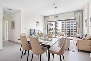 迪拜StoneTree - Spacious 2BR Apartment in Golf Views Block A的用餐室以及带桌椅的起居室。