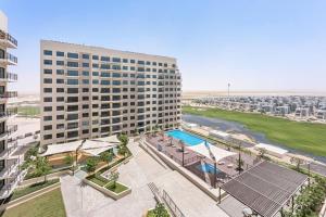 迪拜StoneTree - Spacious 2BR Apartment in Golf Views Block A的享有带游泳池的大型建筑的顶部景色