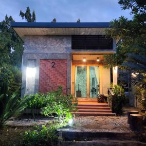 Baan Pak Arom Resort Chanthaburi的砖屋,前门和楼梯