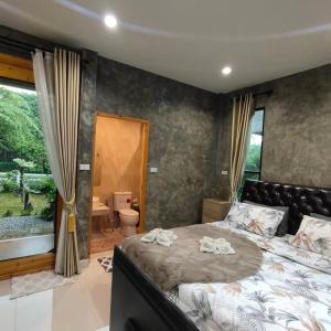 Baan Pak Arom Resort Chanthaburi的一间卧室设有一张大床和一个大窗户
