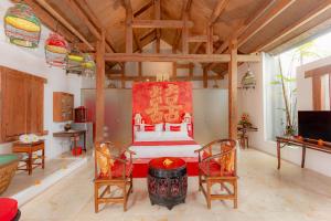 塞米亚克巴厘岛姜套房别墅的一间卧室,卧室内配有一张床和两把椅子