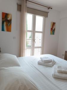 库克里亚Aphrodite Hills Adonis Apartment的一张白色的床,上面有两条毛巾