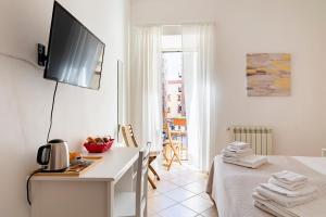 巴勒莫Punto al Capo Appartamento intero o stanze matrimoniali con bagno privato的白色的客房设有一张床和墙上的电视
