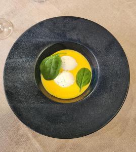 蒙蒂尼雷斯LOGIS Hôtel & Restaurant Le Soleil D'or的一张桌子上带有鸡蛋的黑盘