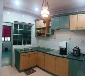 昔加末Homestay No. 8的厨房配有绿色橱柜、水槽和台面