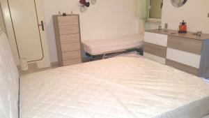 丽都玛里尼Res lido marini的一间卧室配有一张大床和一个梳妆台