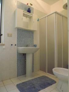 丽都玛里尼Res lido marini的一间带水槽、淋浴和卫生间的浴室