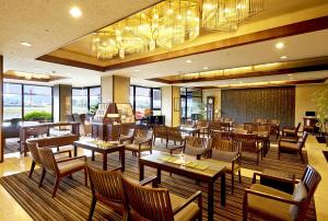 岐阜岐阜酒店的餐厅设有木桌、椅子和窗户。