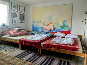 塞默灵local tax 3 Eur guest for night的墙上画画的房间里设有两张床