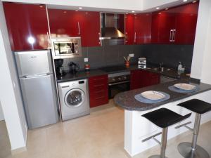 卡武埃鲁Ver-O-Mar的厨房配有红色橱柜、洗衣机和烘干机