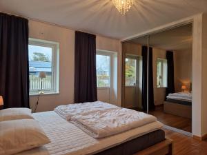 梅尔比斯特兰德Mellby Kite Surf Villa的一间卧室设有一张大床和一个大镜子