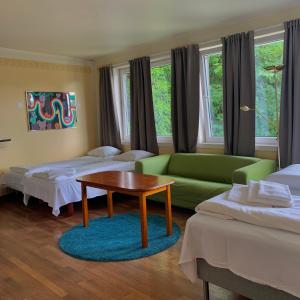 曼达尔SKAP Hostel Mandal的客房设有两张床、一张沙发和一张桌子。