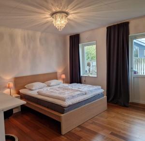 梅尔比斯特兰德Mellby Kite Surf Villa的一间卧室配有一张大床和一个吊灯。